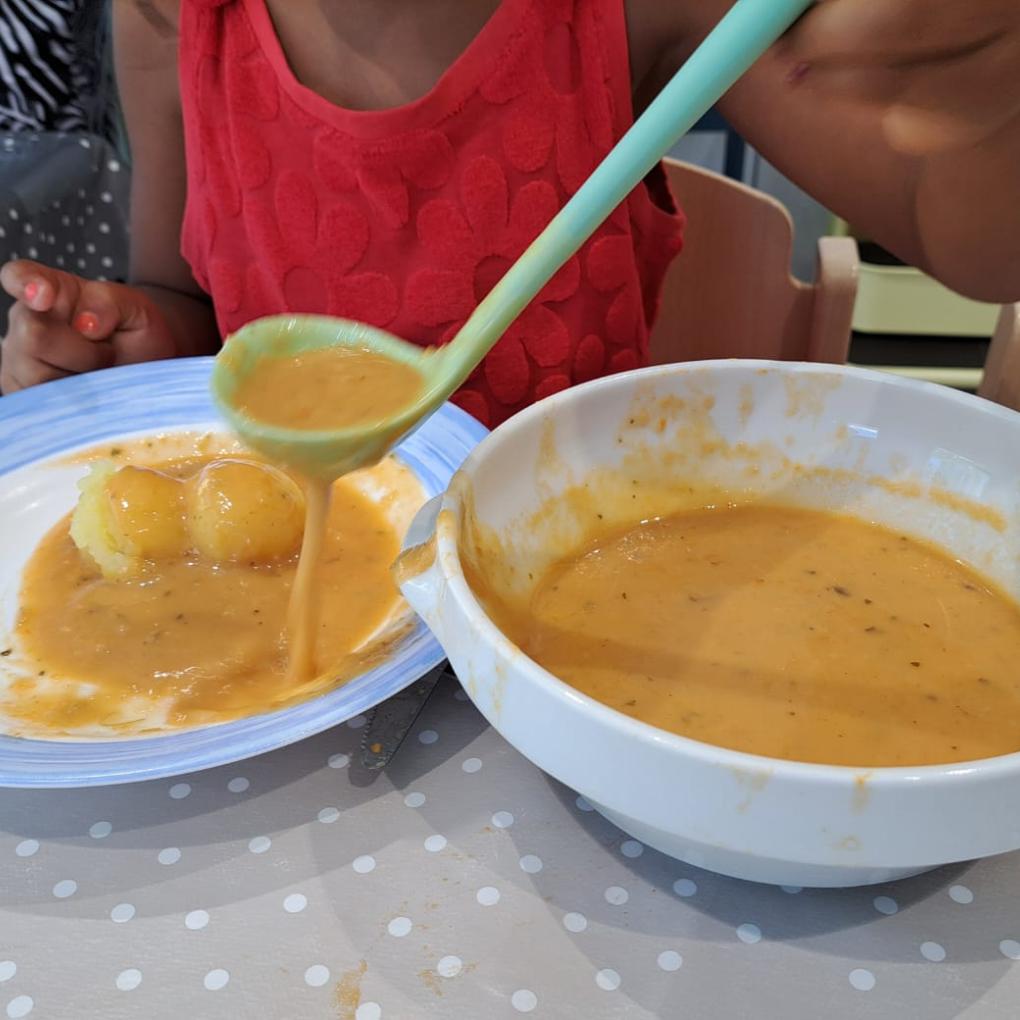 Kind schöpft Essen